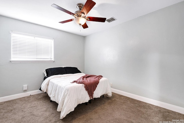carpeted bedroom featuring baseboards, a ceiling fan, and visible vents