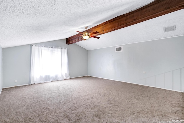 carpeted empty room featuring ceiling fan, a textured ceiling, visible vents, baseboards, and vaulted ceiling with beams