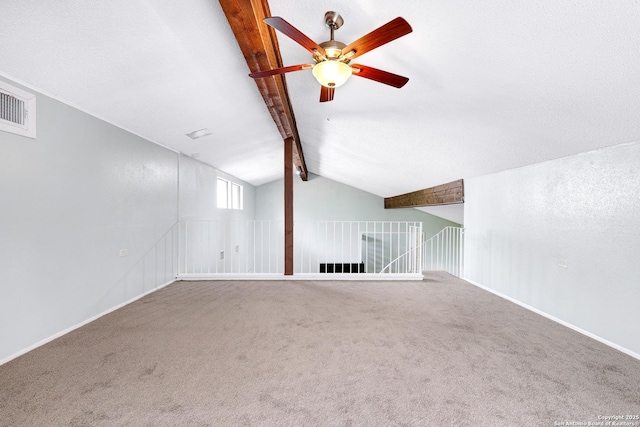 additional living space with a ceiling fan, visible vents, baseboards, lofted ceiling with beams, and carpet
