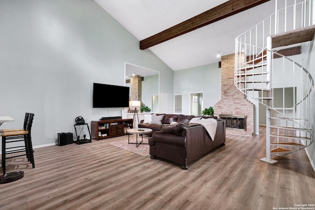 living area featuring stairs, high vaulted ceiling, wood finished floors, and beamed ceiling