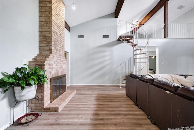 living room featuring stairs, high vaulted ceiling, visible vents, and a brick fireplace