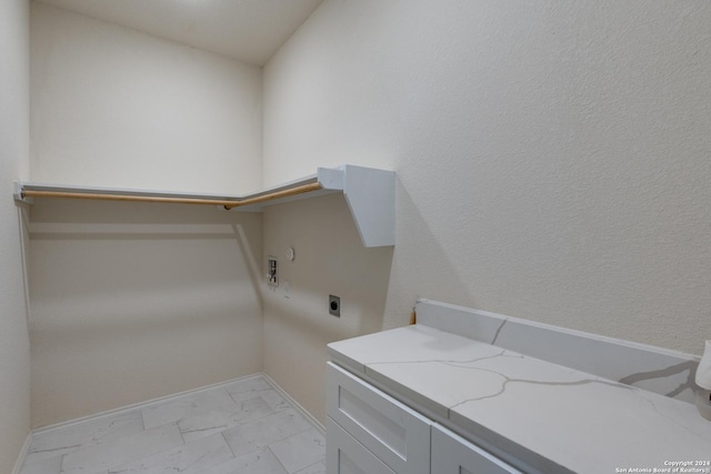 laundry room with electric dryer hookup, marble finish floor, cabinet space, and baseboards