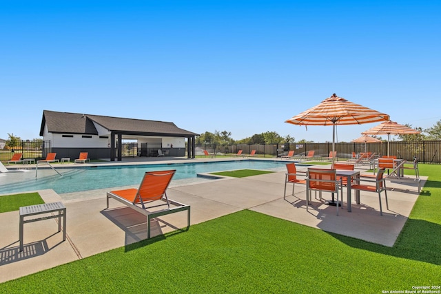 pool featuring fence, a yard, and a patio area