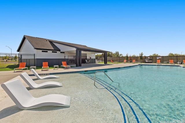 pool with fence and a patio area