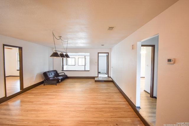 interior space with baseboards, visible vents, and light wood-type flooring
