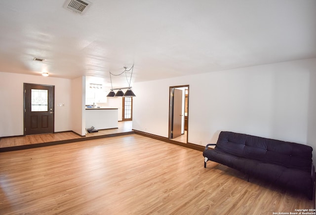 living room with baseboards, visible vents, and light wood-style floors