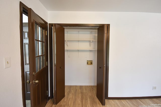 corridor featuring baseboards and light wood finished floors