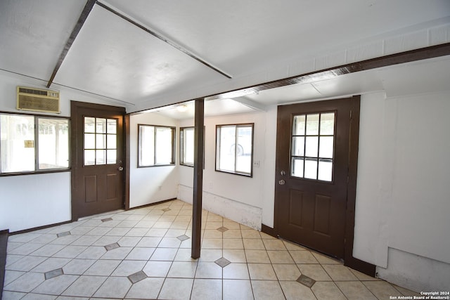 foyer entrance with baseboards, vaulted ceiling, and a wall mounted air conditioner
