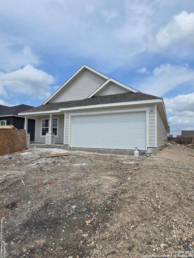view of front of home with an attached garage and dirt driveway