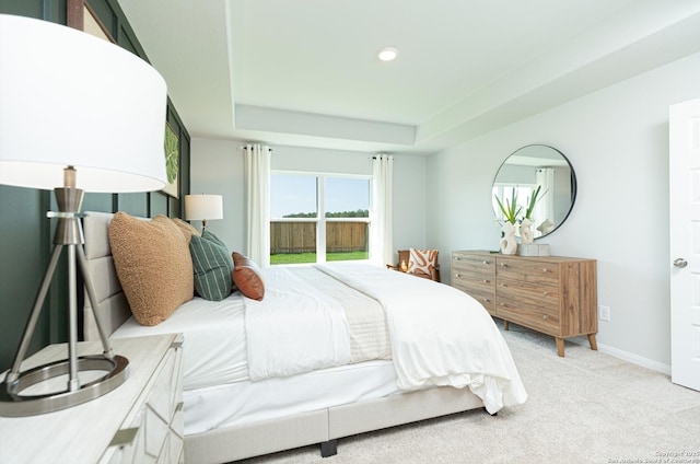 bedroom featuring recessed lighting, a raised ceiling, baseboards, and light carpet