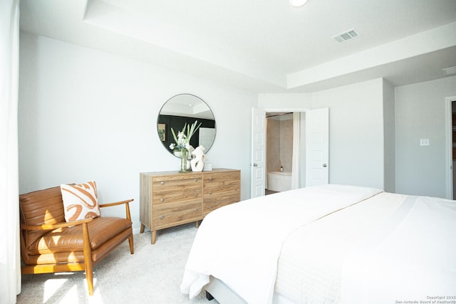 bedroom with visible vents, a raised ceiling, and light colored carpet