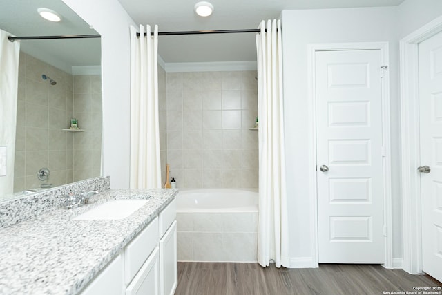 full bathroom featuring tiled shower / bath combo, wood finished floors, and vanity