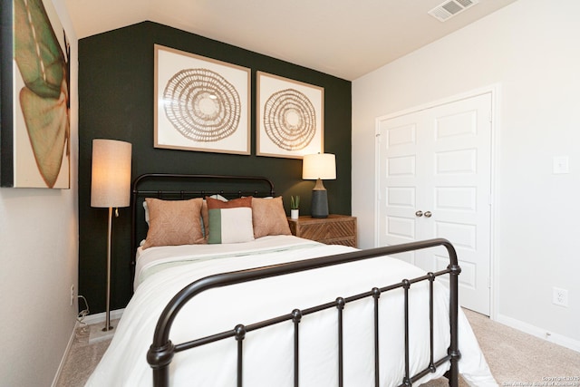 carpeted bedroom with baseboards, visible vents, and vaulted ceiling