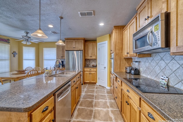 kitchen featuring ceiling fan, appliances with stainless steel finishes, a sink, and visible vents