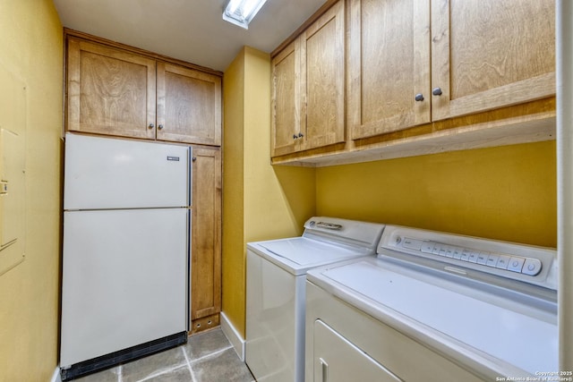 washroom with tile patterned floors, baseboards, cabinet space, and independent washer and dryer