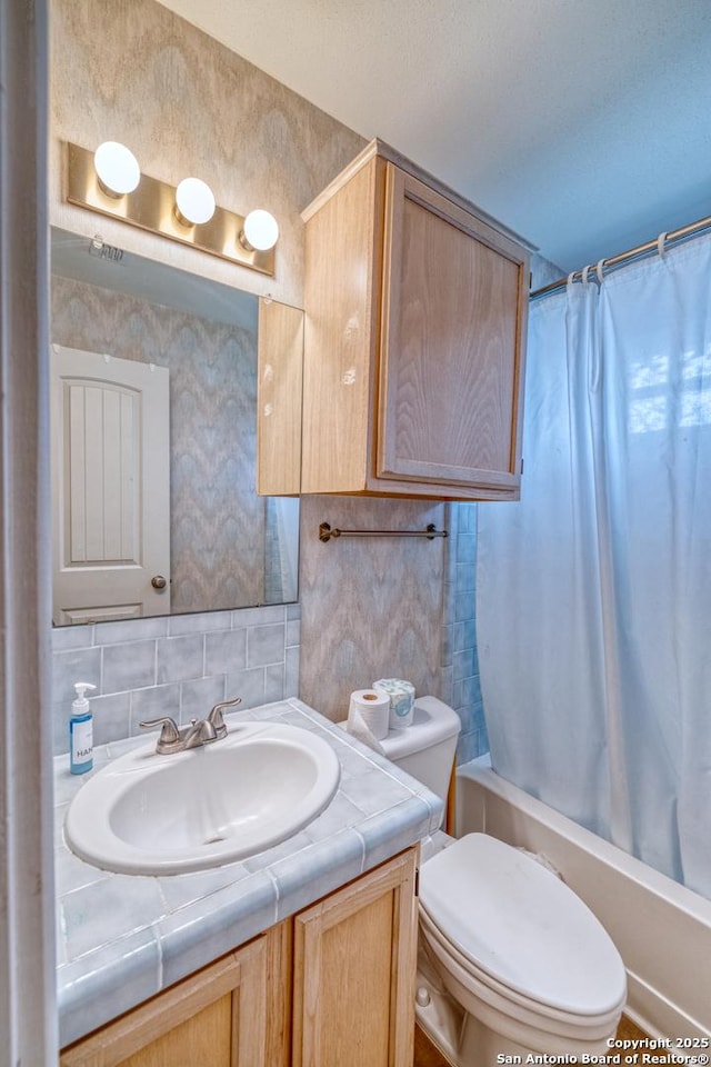 bathroom with vanity, decorative backsplash, shower / bath combo with shower curtain, and toilet