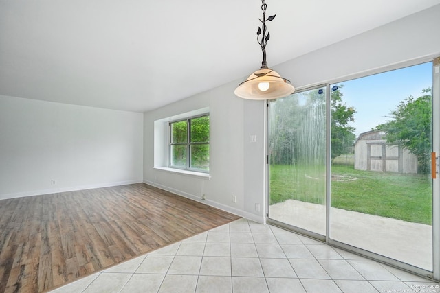 unfurnished dining area with baseboards and wood finished floors