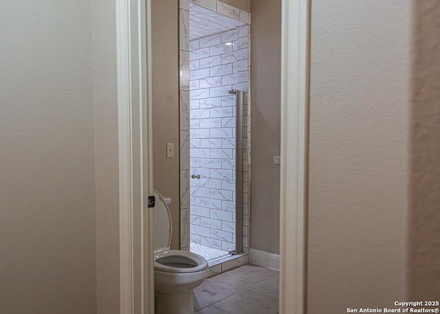 full bath featuring tile patterned floors, toilet, and a shower stall