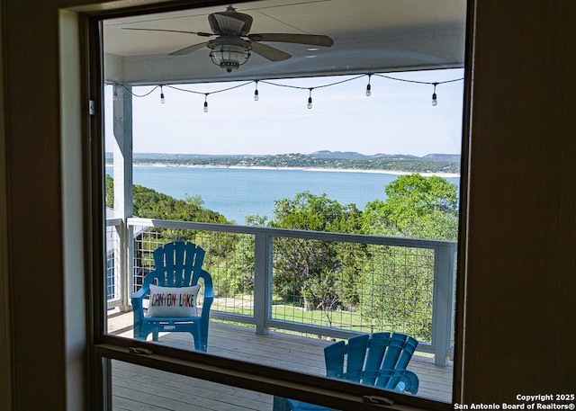interior space with a water view and ceiling fan
