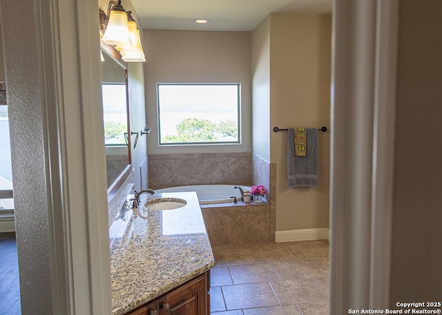 full bath with vanity, baseboards, a garden tub, and recessed lighting