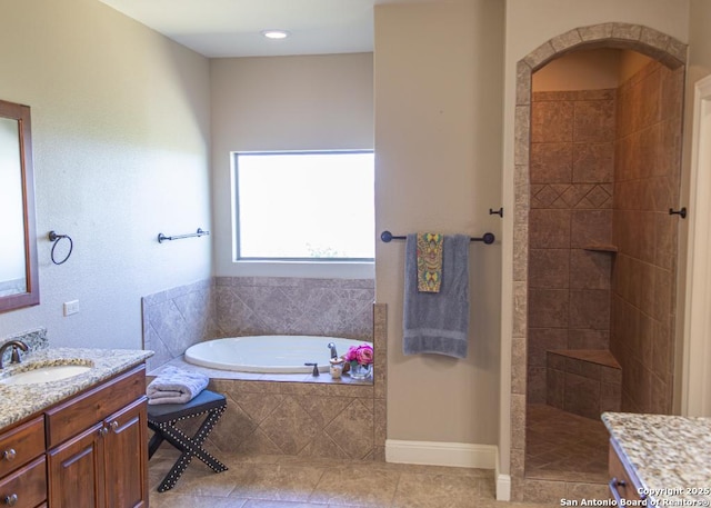 full bathroom featuring vanity, tile patterned flooring, walk in shower, and a garden tub
