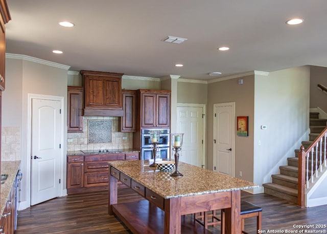 kitchen featuring stainless steel double oven, tasteful backsplash, visible vents, and dark wood-type flooring
