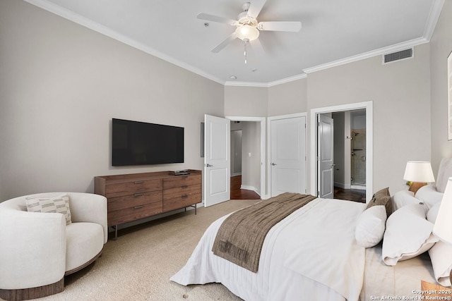 bedroom featuring visible vents, crown molding, carpet floors, ceiling fan, and ensuite bath