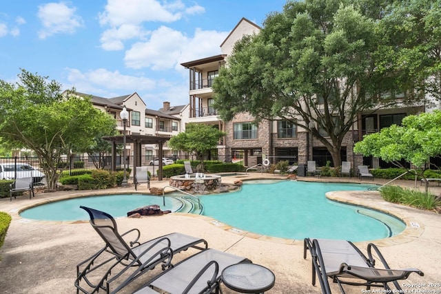 community pool featuring fence and a patio area