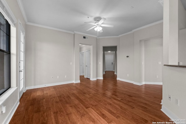 empty room with crown molding, ceiling fan, wood finished floors, and visible vents