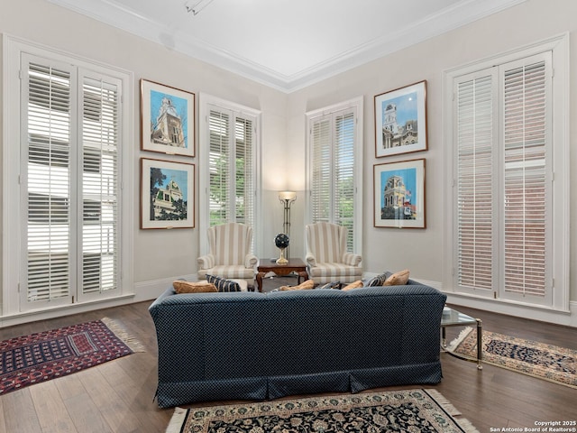 sitting room featuring crown molding, baseboards, and wood finished floors