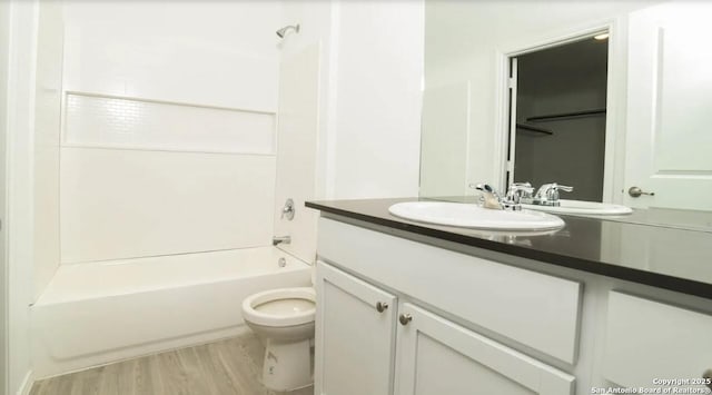 full bath with vanity, wood finished floors, toilet, and shower / washtub combination