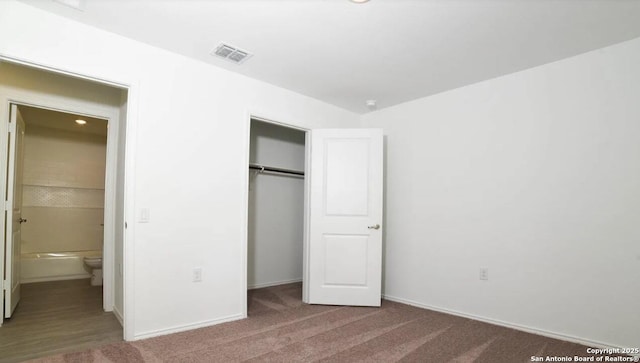 unfurnished bedroom featuring baseboards, visible vents, carpet, and a closet