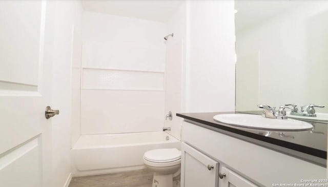 bathroom featuring vanity, wood finished floors, bathtub / shower combination, and toilet