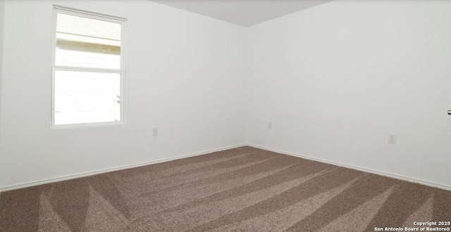 carpeted empty room featuring baseboards
