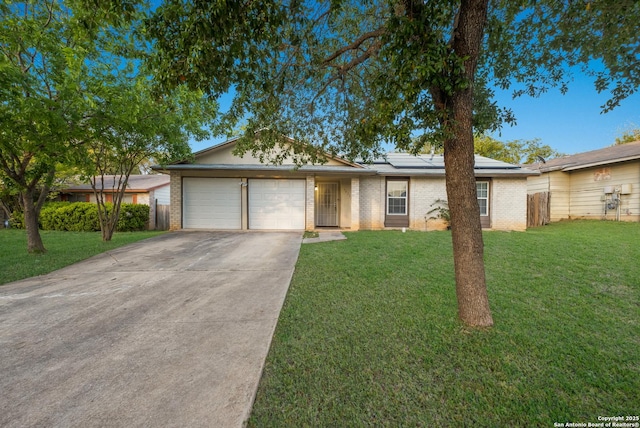 single story home featuring brick siding, driveway, a front yard, and a garage