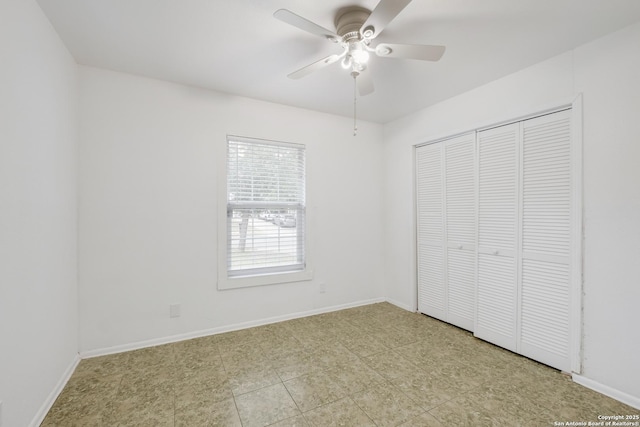 unfurnished bedroom with baseboards, a ceiling fan, and a closet