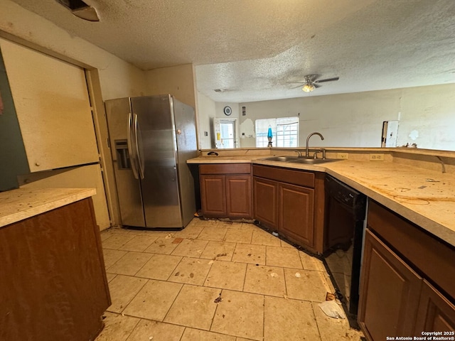 kitchen with ceiling fan, stainless steel refrigerator with ice dispenser, a textured ceiling, a sink, and black dishwasher