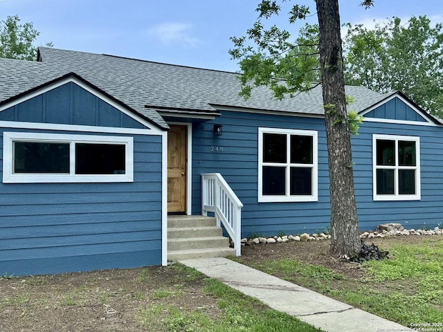 view of front of home featuring board and batten siding and roof with shingles