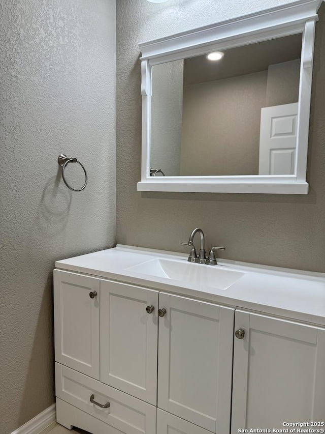 bathroom with vanity and a textured wall