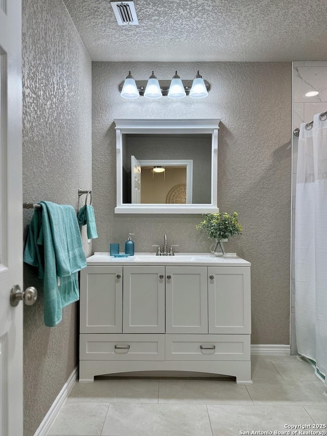 full bathroom featuring tile patterned floors, a textured wall, and visible vents