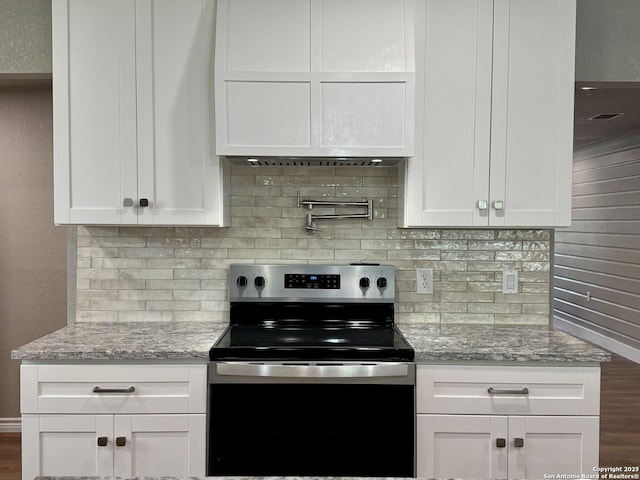 kitchen with white cabinetry, light stone countertops, decorative backsplash, and electric stove