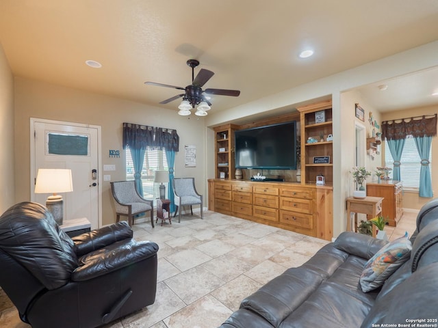 living room featuring a ceiling fan and a wealth of natural light