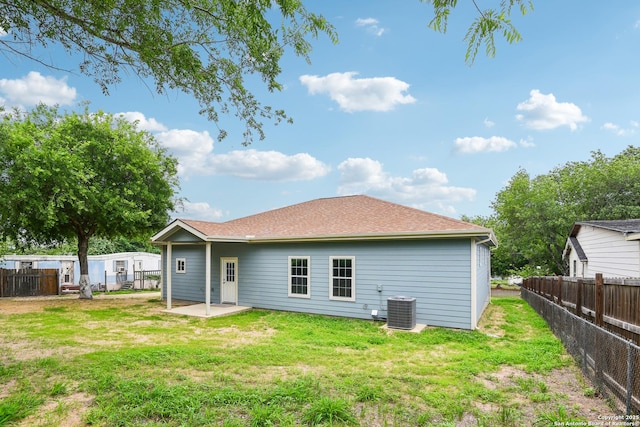 rear view of property featuring a fenced backyard, central AC unit, a lawn, and a patio