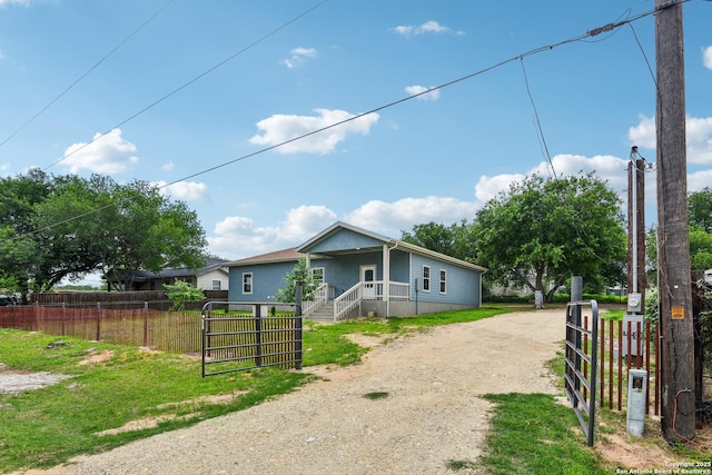 view of front of house with a fenced front yard, a gate, and dirt driveway