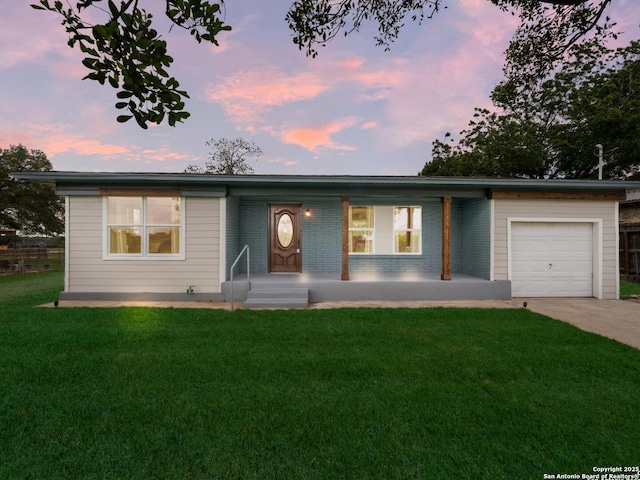 ranch-style house with brick siding, a garage, a yard, and driveway