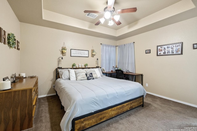 113 E Dawn Dr, Johnson City, TX 78636 - carpeted bedroom featuring a ceiling fan, a tray ceiling, visible vents, and baseboards