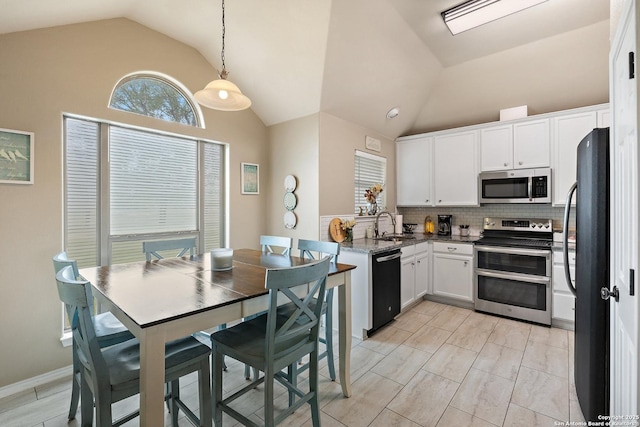 113 E Dawn Dr, Johnson City, TX 78636 - kitchen featuring backsplash, a sink, white cabinets, lofted ceiling, and stainless steel appliances