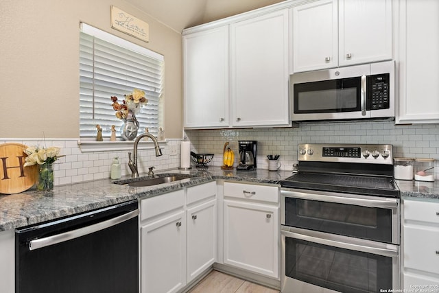 113 E Dawn Dr, Johnson City, TX 78636 - kitchen featuring a sink, decorative backsplash, stainless steel appliances, and white cabinets