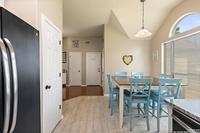 113 E Dawn Dr, Johnson City, TX 78636 - dining area featuring baseboards, vaulted ceiling, visible vents, and wood tiled floor