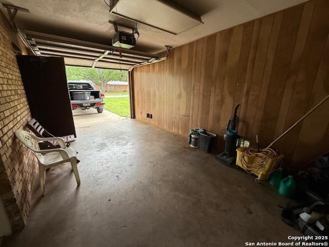 4519 Creekmoor, San Antonio, TX 78220 - garage featuring wood walls and a garage door opener